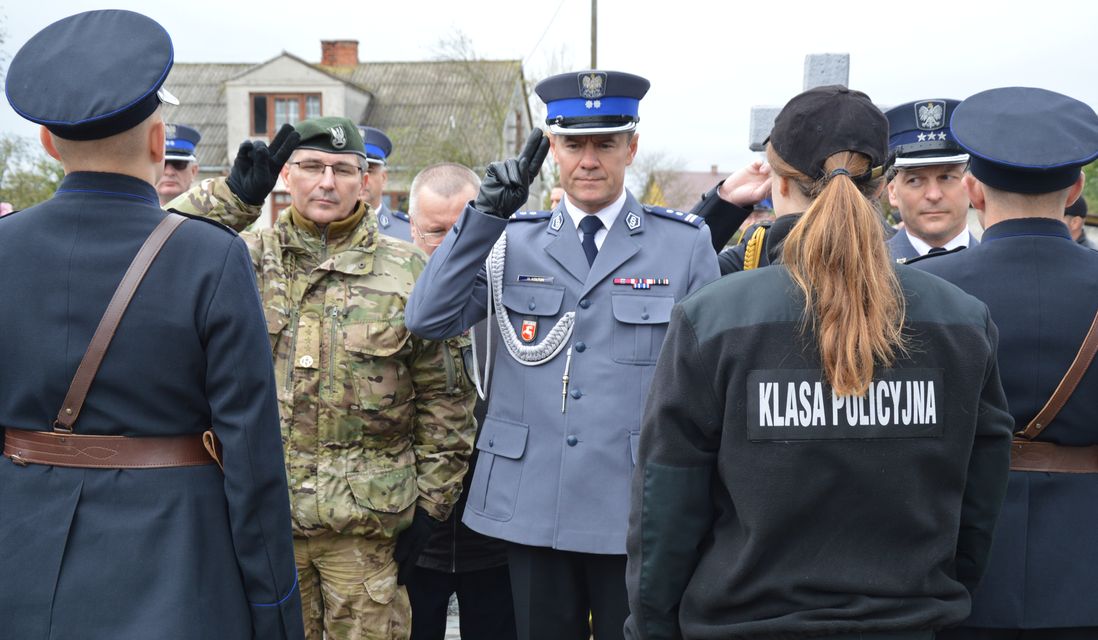 Komendant Miejski Policji w Chełmie oddaje honor w asyście przedstawicieli innych służb.